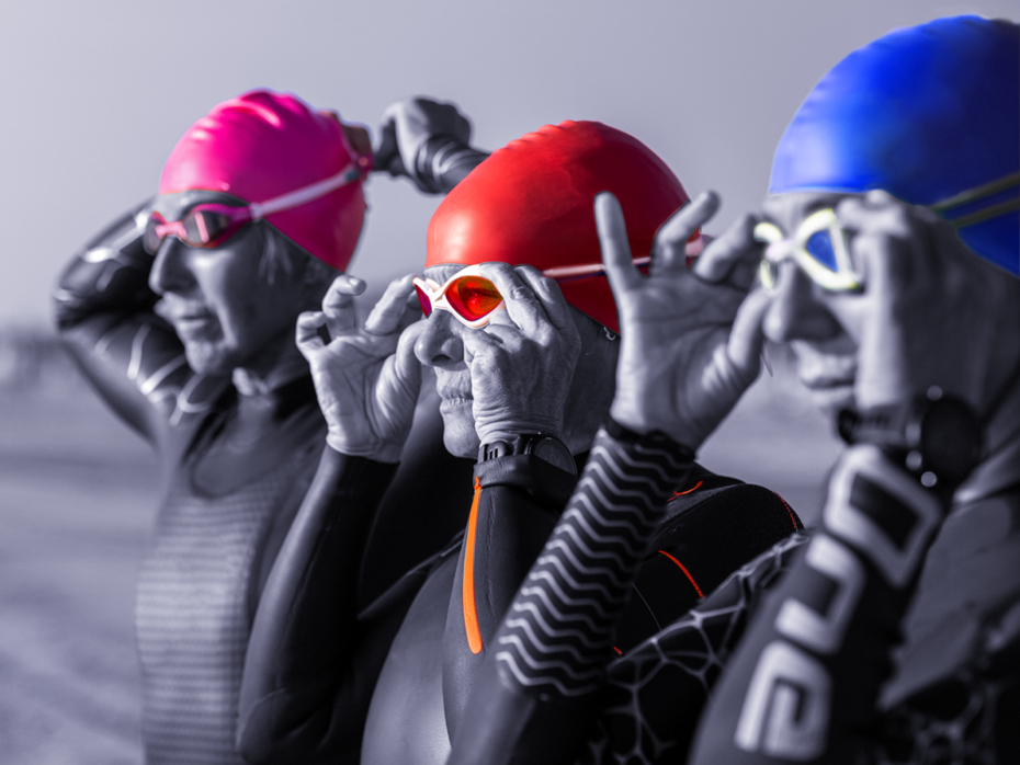 Three female swimmers getting ready to take the plunge